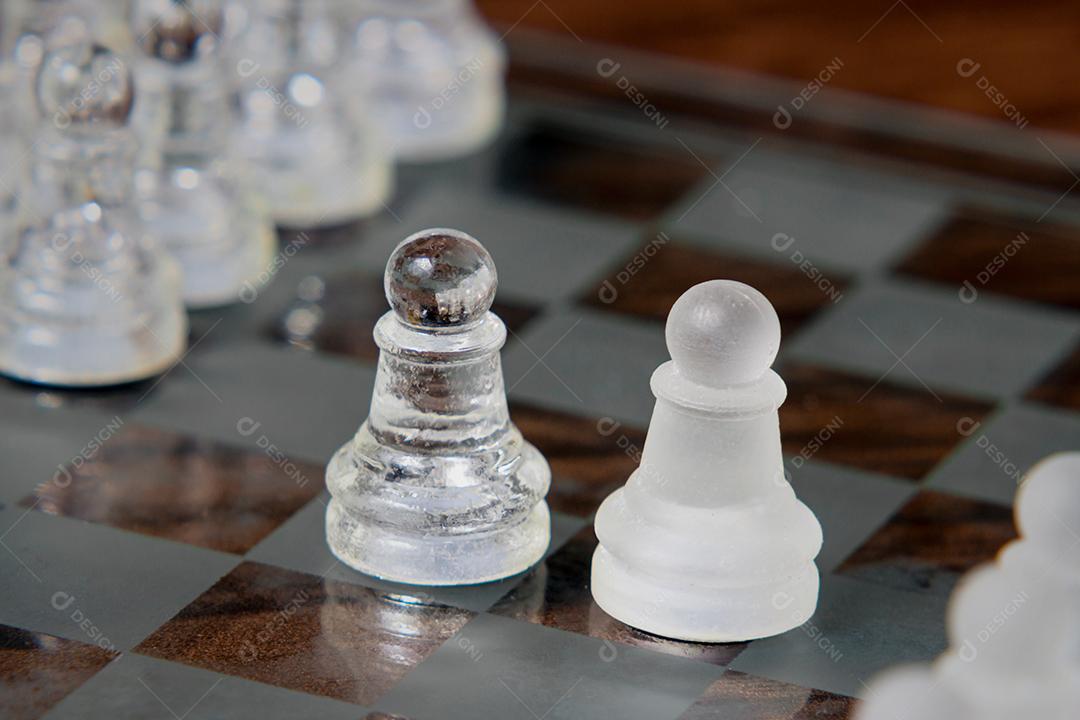 Xadrez de jogo de tabuleiro com peças de xadrez na frente de fundo branco.