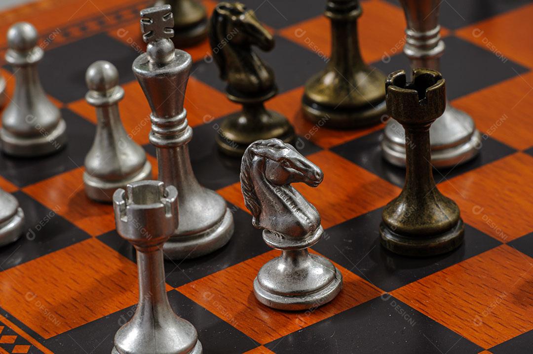 Peças de xadrez de metal em um tabuleiro de xadrez