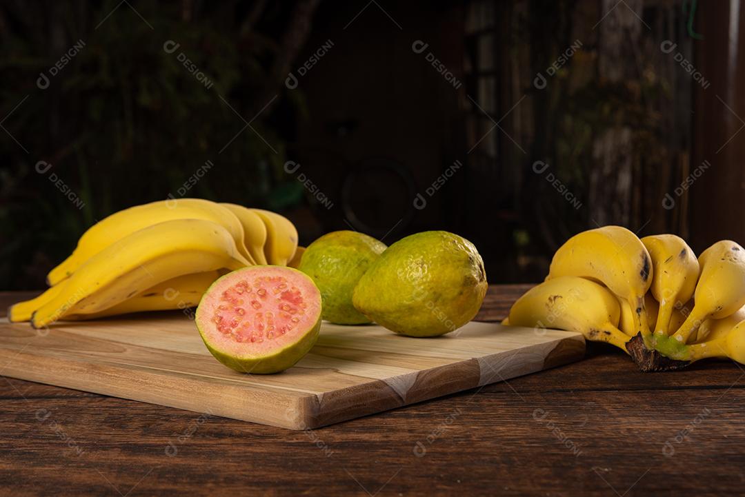 Bananas E Goiabas Em Mesa De Madeira Polida Imagem JPG