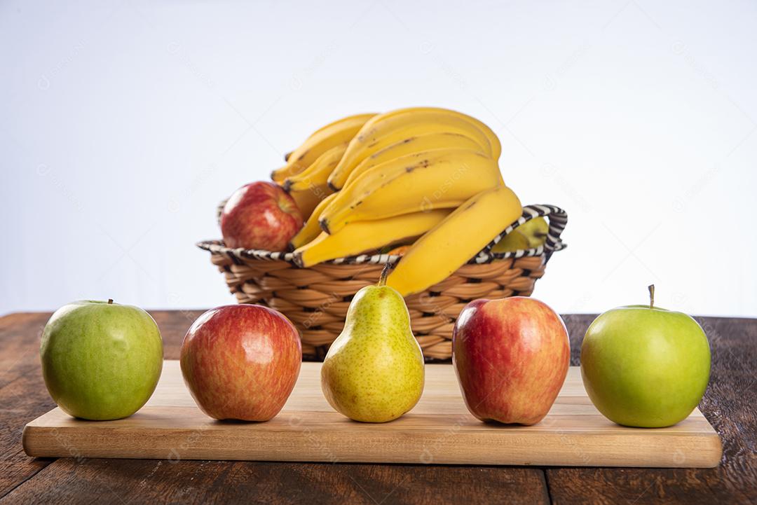 Cesta De Frutas Com Bananas Maçãs Peras E Laranjas Em Mesa De Madeira Polida Imagem JPG