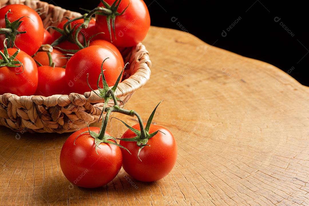 Tomates Em Uma Cesta De Palha Sobre Madeira Imagem JPG