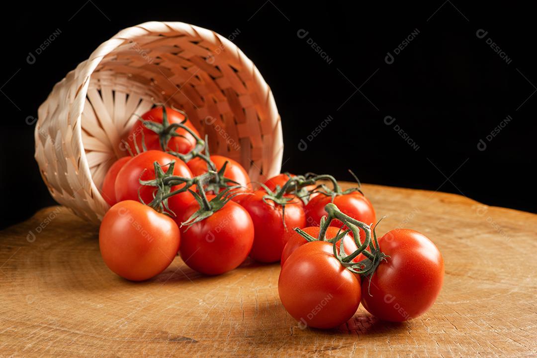Tomates Caido De Cesta De Palha Sobre Mesa De Madeira Imagem JPG