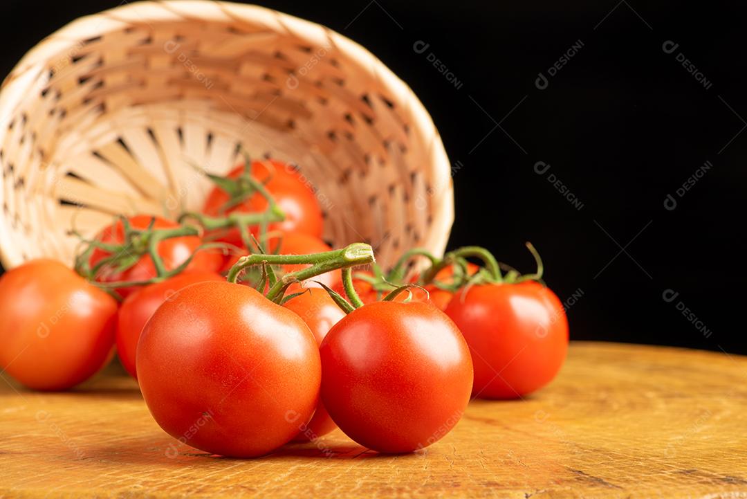 Tomates Caido De Cesta De Palha Sobre Madeira Imagem JPG