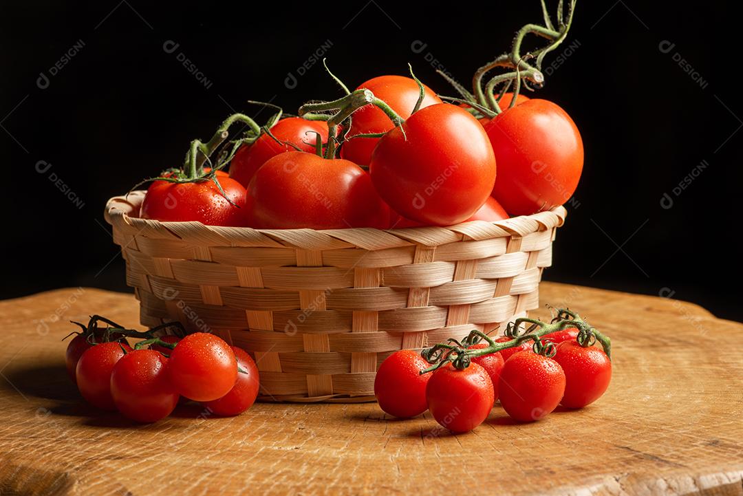 Tomates Em Uma Cesta De Palha Sobre Madeira Imagem JPG