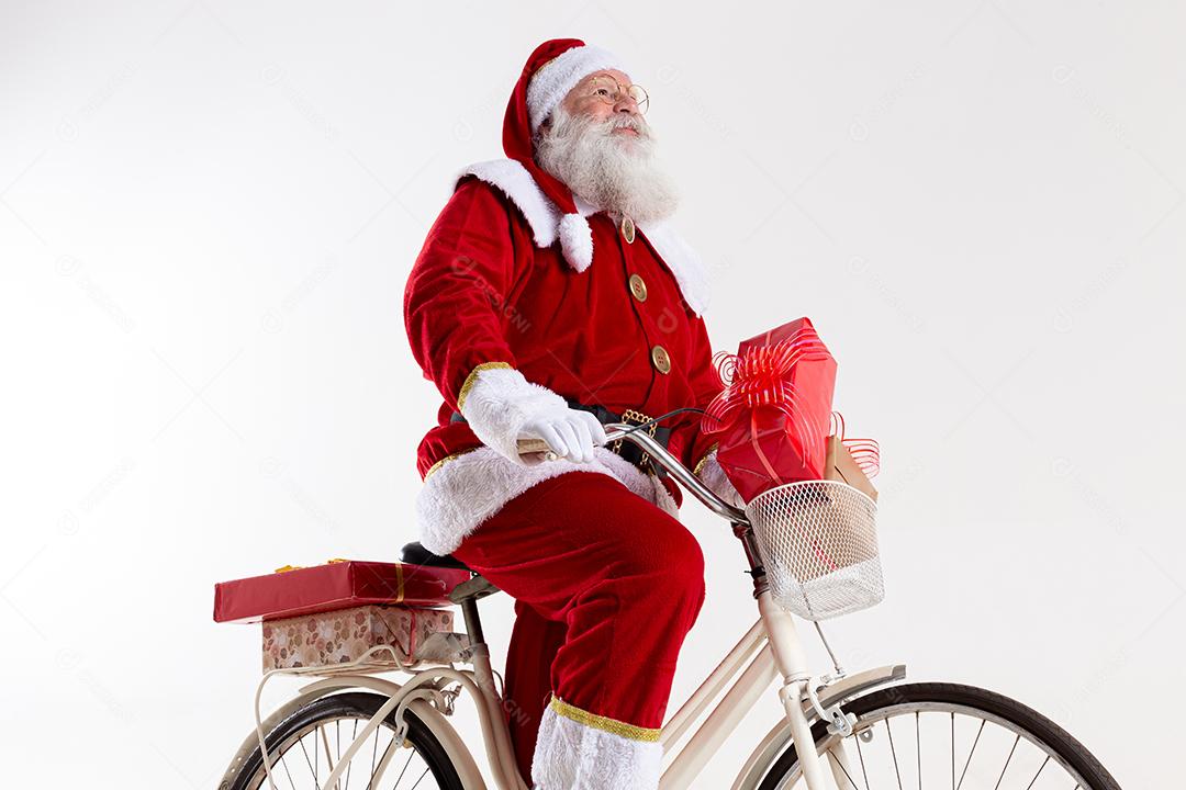 Papai Noel de bicicleta entregando presentes de Natal.