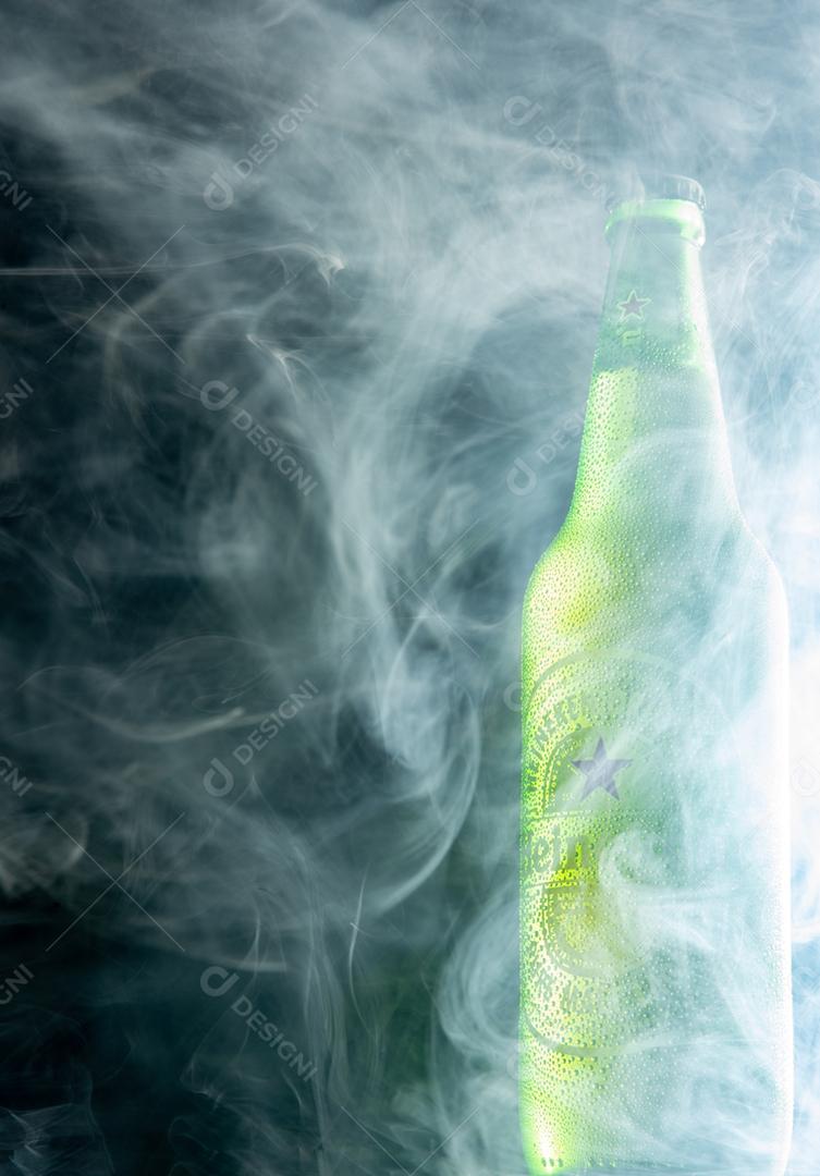 Garrafa de heineken envolta em fumaça fotografada com fundo escuro
