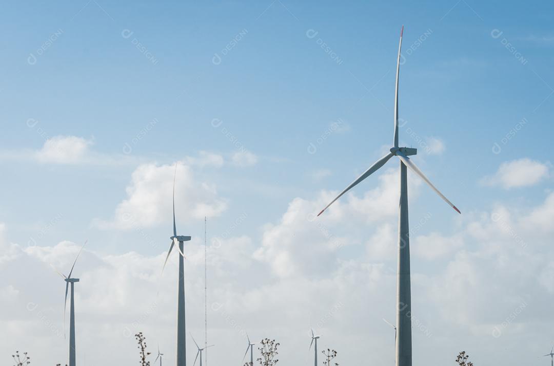 Moinhos de vento durante o dia de verão brilhante com céu azul, conceito de energia limpa e renovável