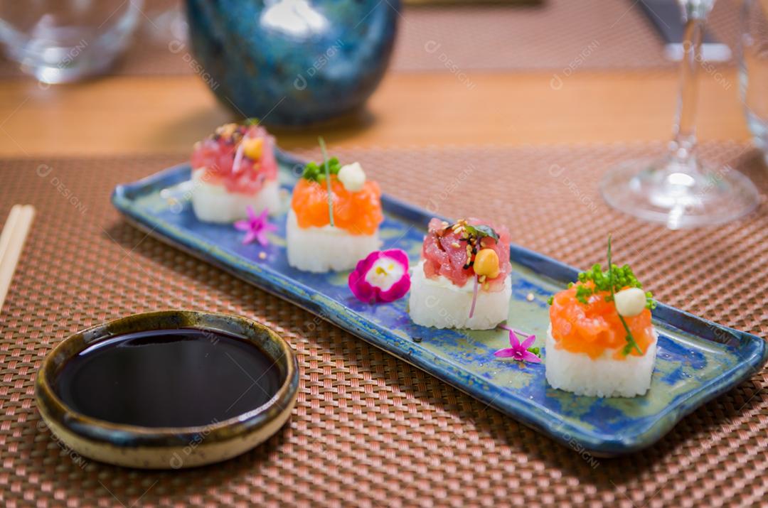 Delicioso sushi premium de salmão e atum Oshizushi em um prato de porcelana artesanal decorado.