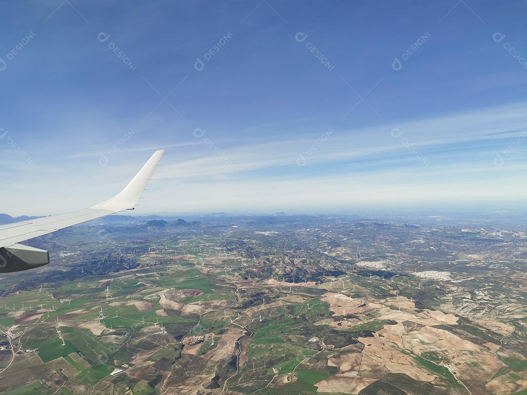 Vista aérea de montanhas e hélices de energia eólica.