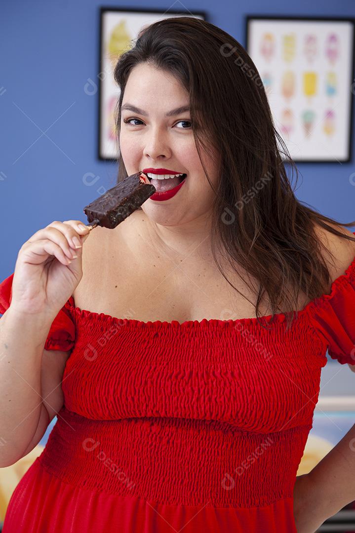 Linda senhora protegida de picolé de morango com cobertura de chocolate.