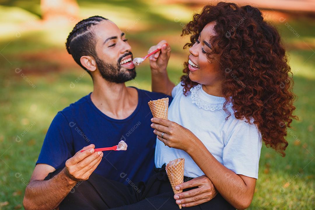 Casal de namorados tomando sorvete no parque