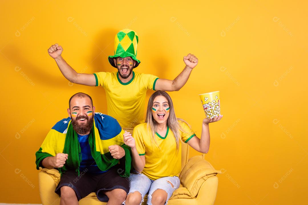 Grupo de amigos assistindo jogo de futebol na televisão, celebrando