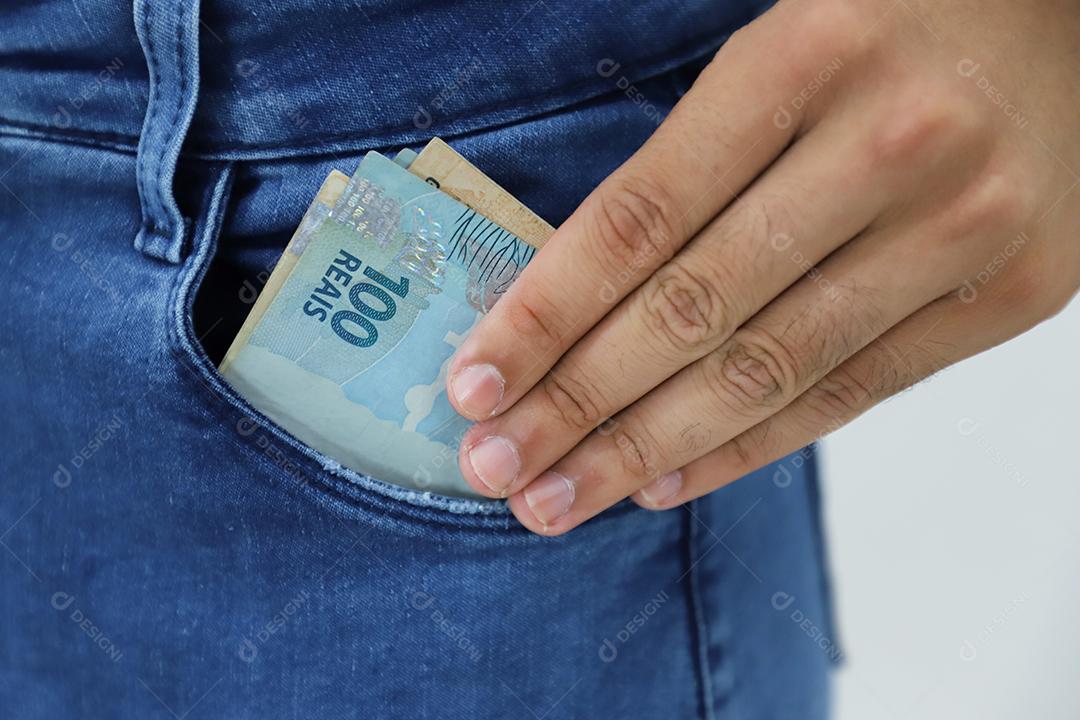 Mãos de pessoas pegando dinheiro de bolso de calça