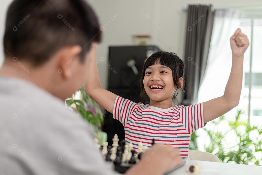 Menino e menina estão jogando xadrez em casa. Crianças jogando xadrez  [download] - Designi