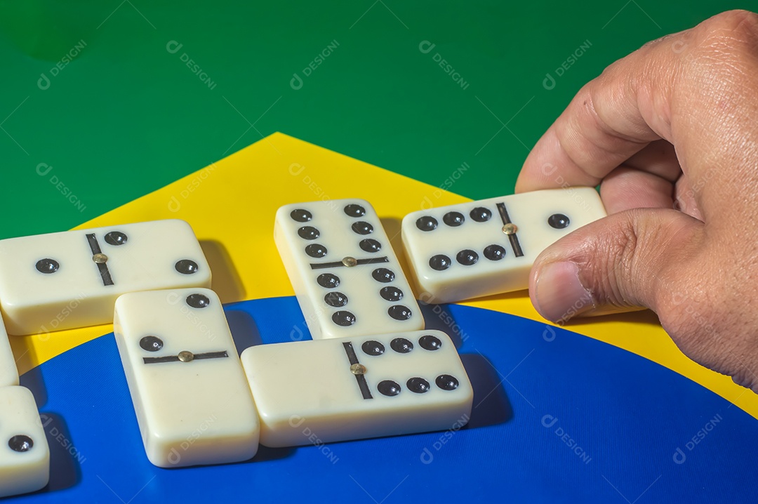 Jogo de dominó sobre uma bandeira verde amarela e azul, colo