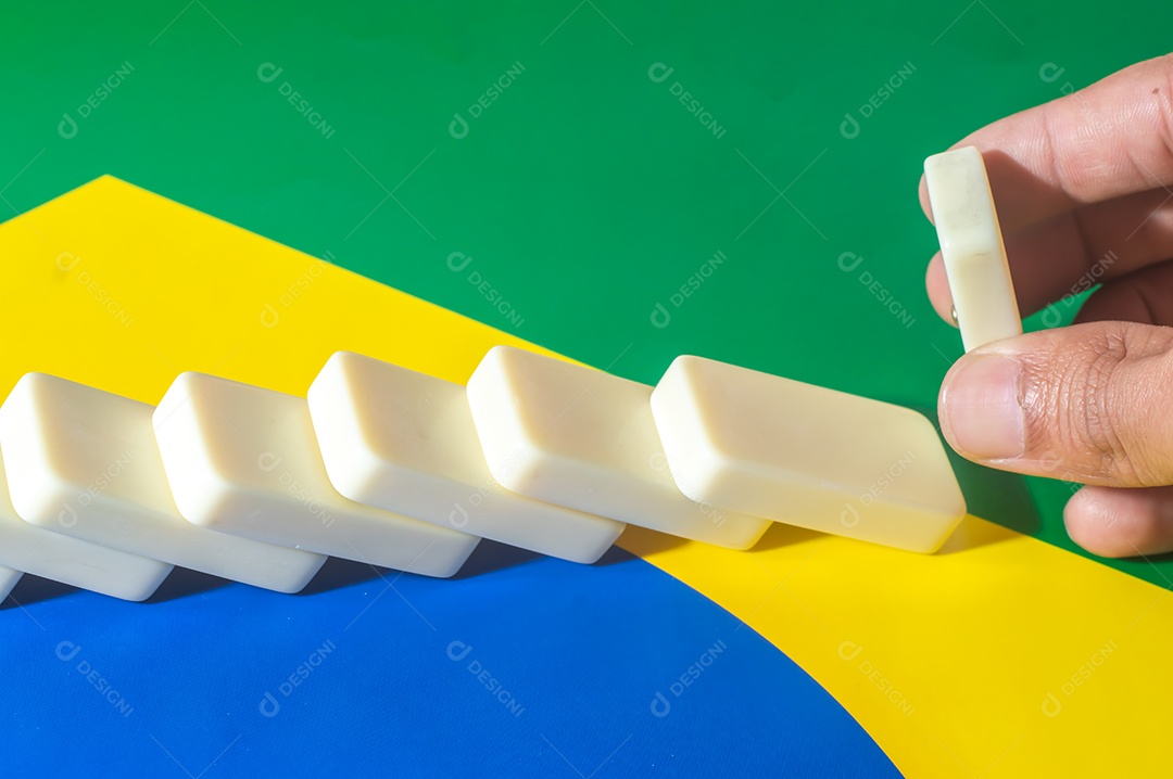 Jogo de dominó sobre uma bandeira verde amarela e azul, colo