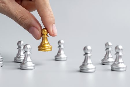 Peças de peão de xadrez dourado ou empresário líder se destacam do corvo.  [download] - Designi