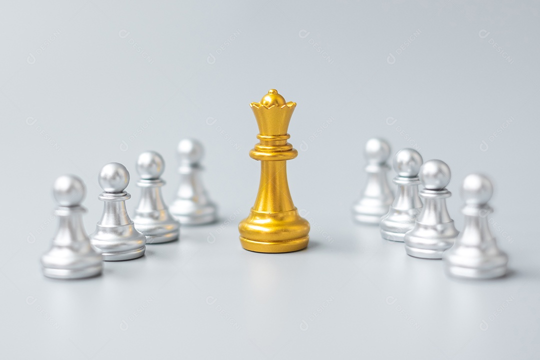 Mão segurando o rei do xadrez de ouro sobre o rei do xadrez de prata