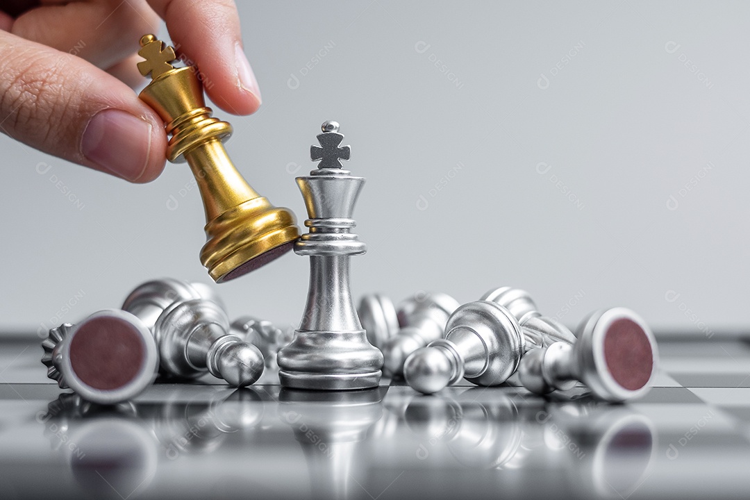 Mãos de empresário movendo o rei do xadrez para a posição de